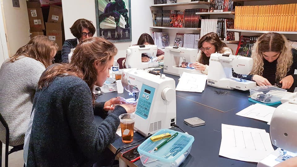 des élèves autour d'une table dans les ateliers de cours de couture Paris